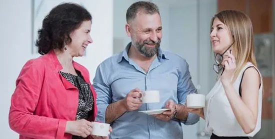 three people drinking coffee and talking